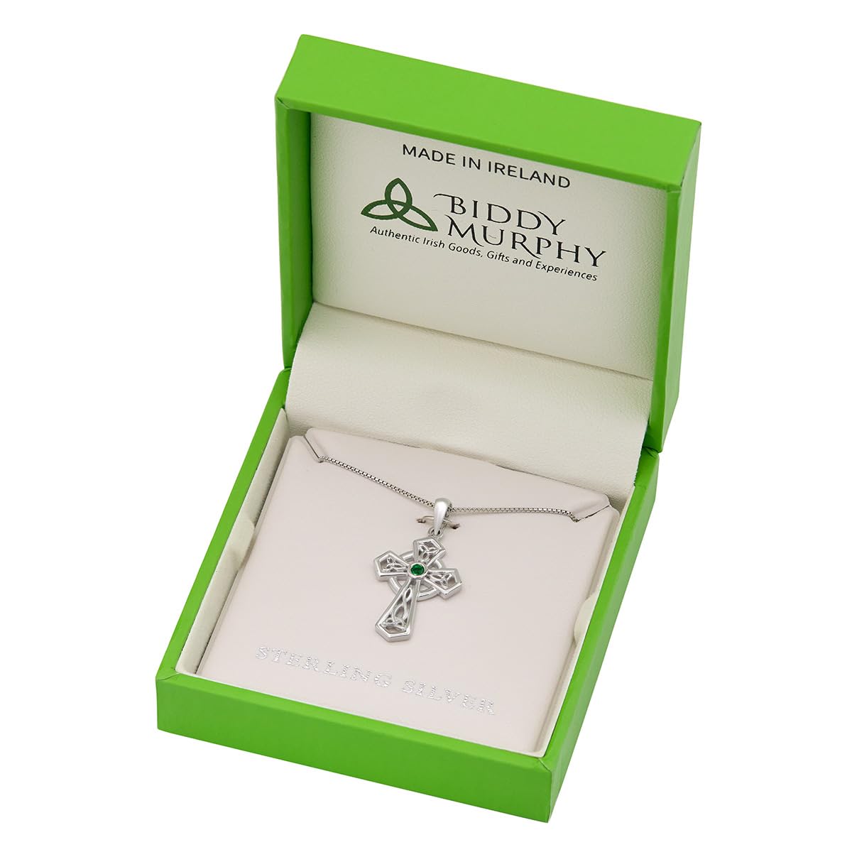 Silver cross necklace with green gemstone in a Biddy Murphy box on a white background